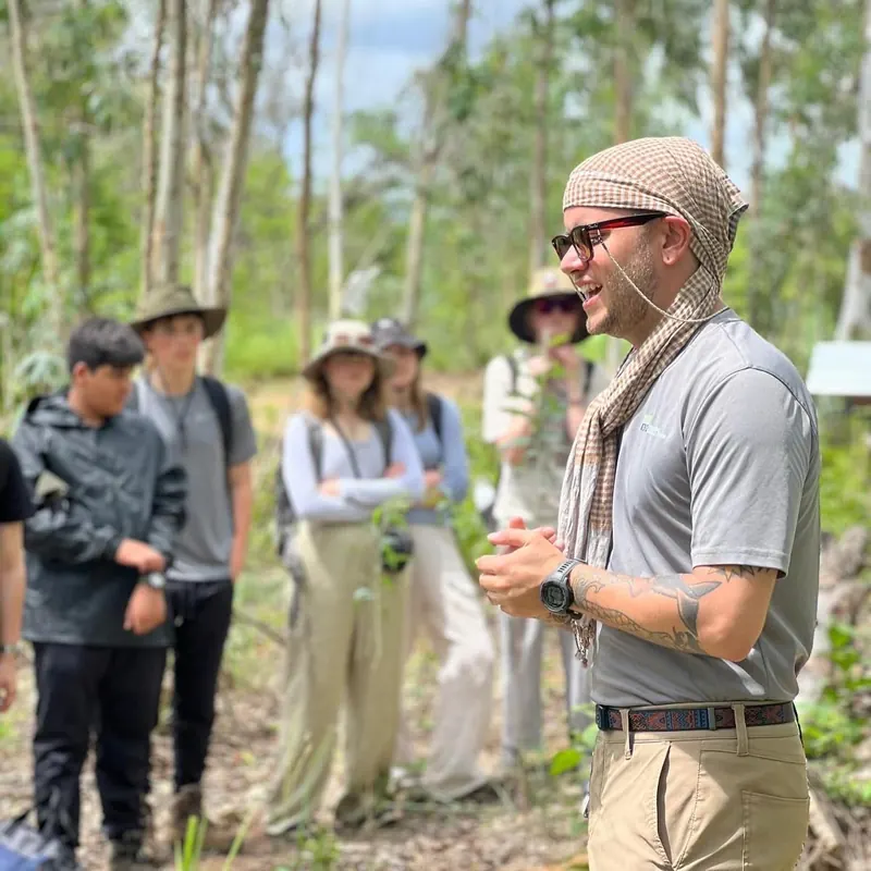 Tyler briefs a group of students in the forest