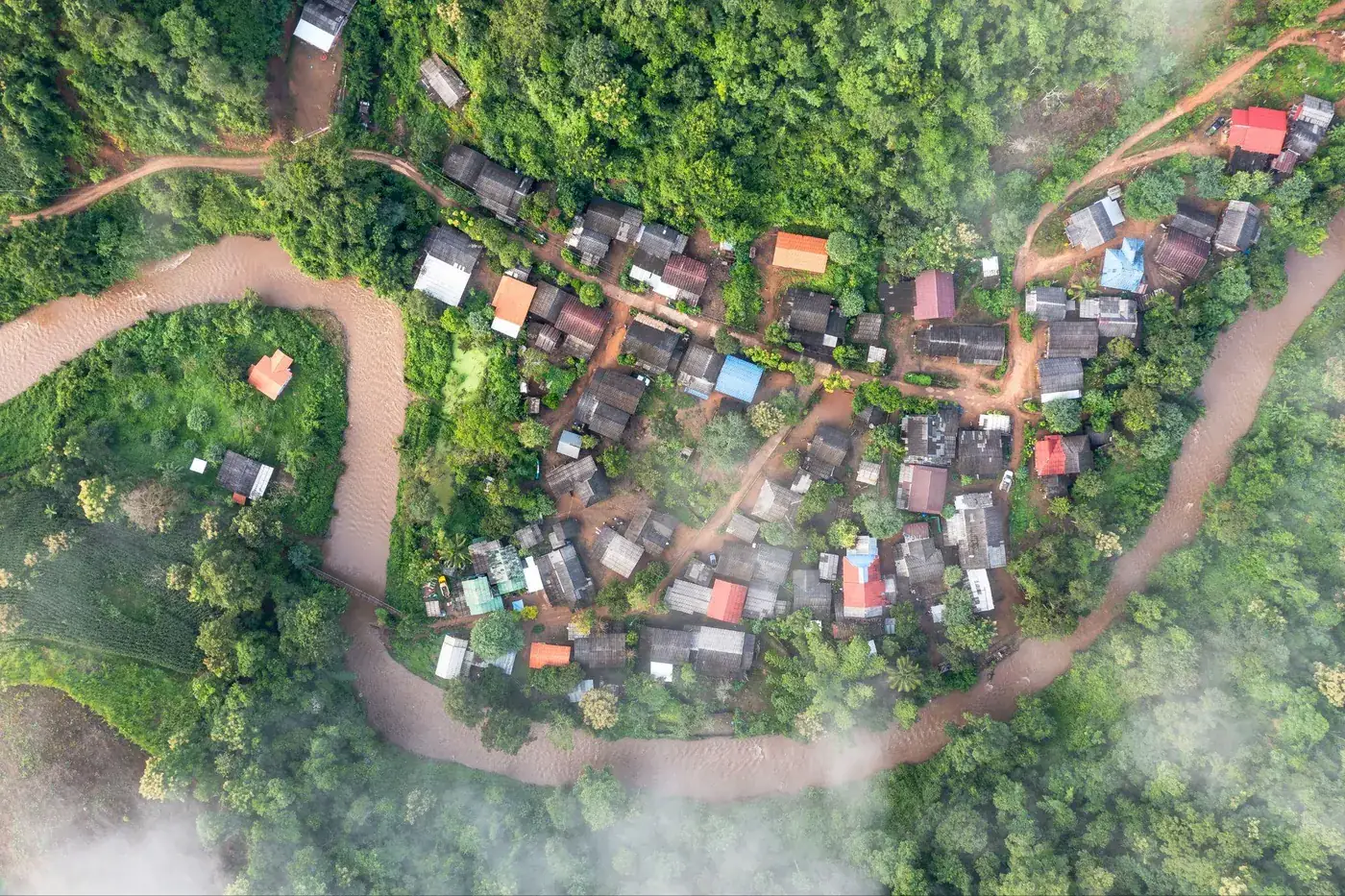 A Karen village beside a river seen from above, with forest on every side